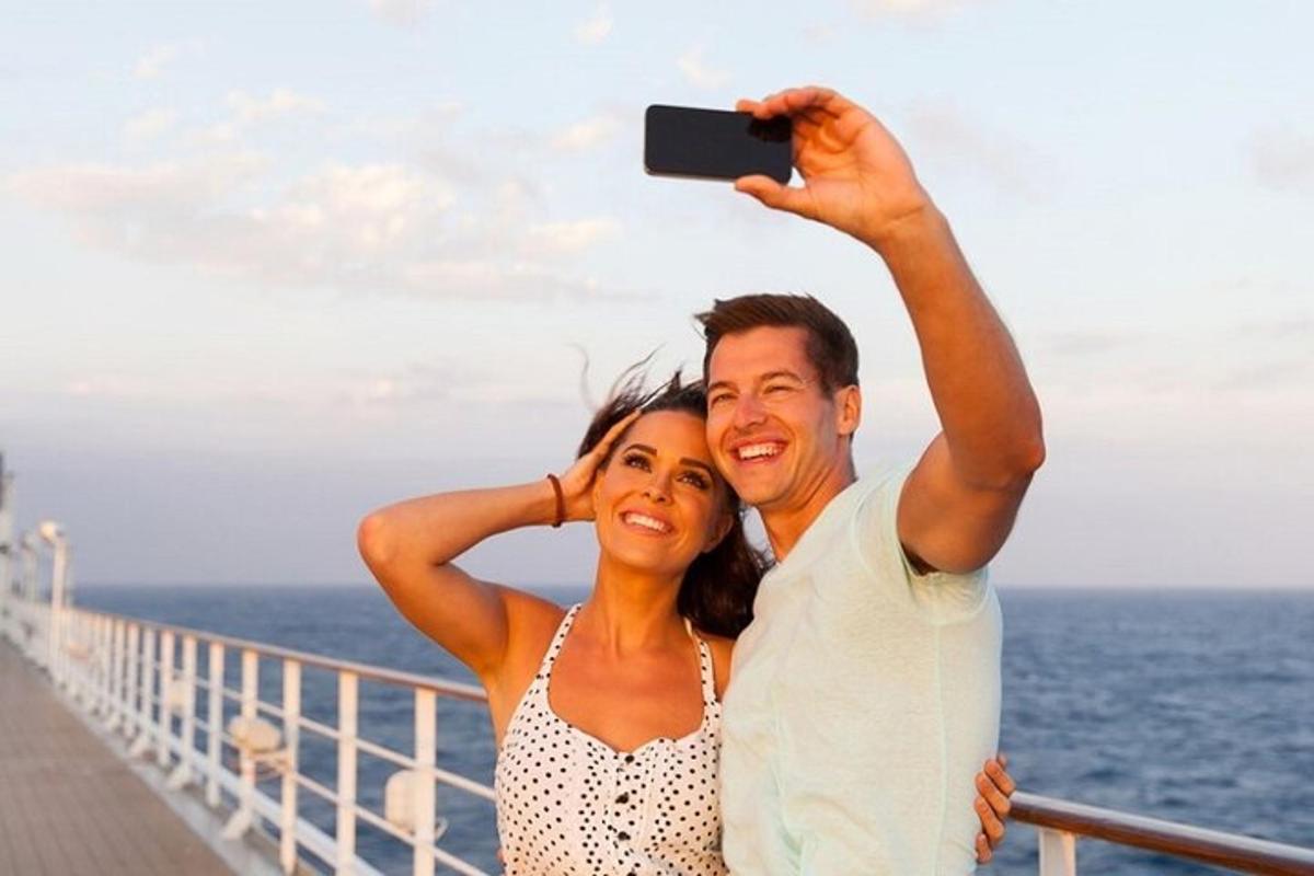un uomo e una donna che scattano una foto su una nave da crociera