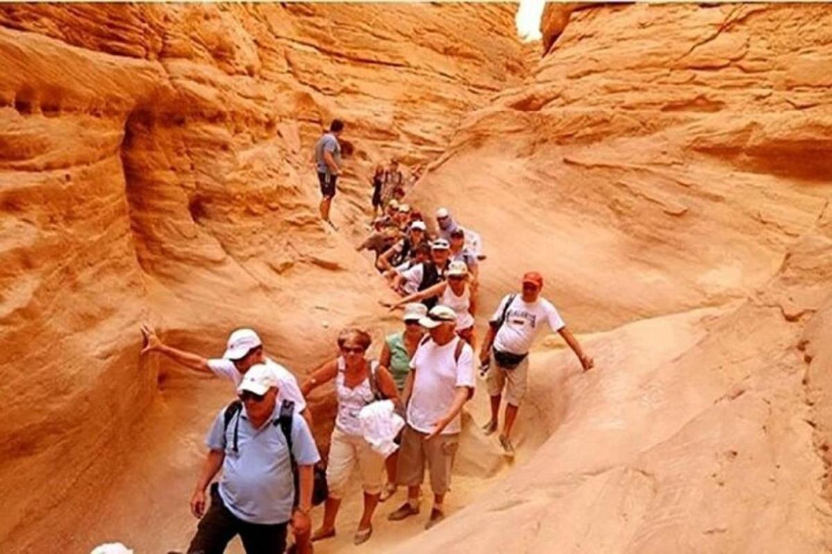 a group of people walking through a canyon