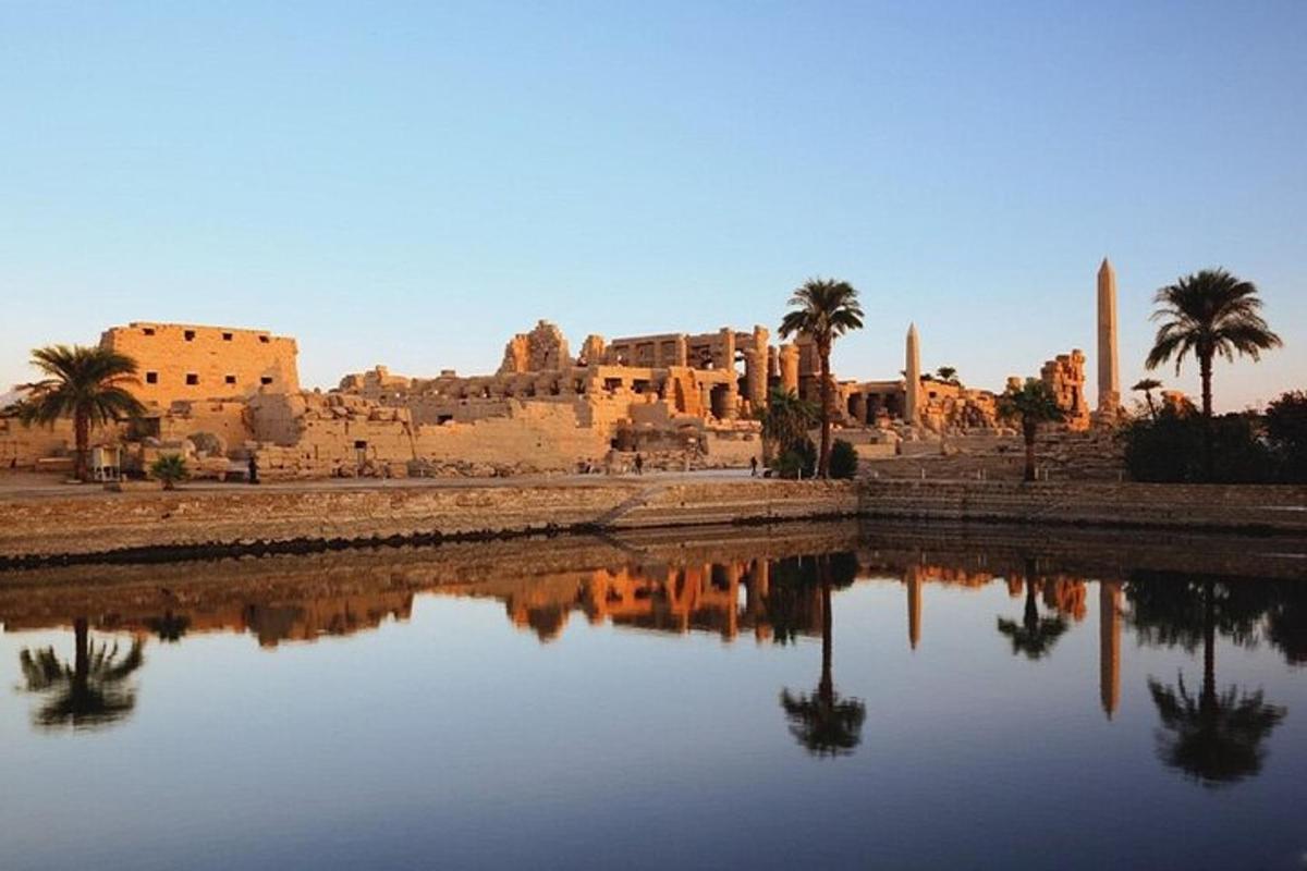 a building with palm trees and a body of water