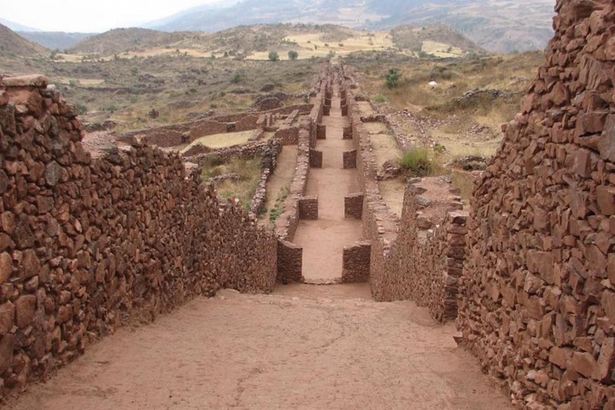 Una vista de un muro de piedra con una montaña al fondo.
