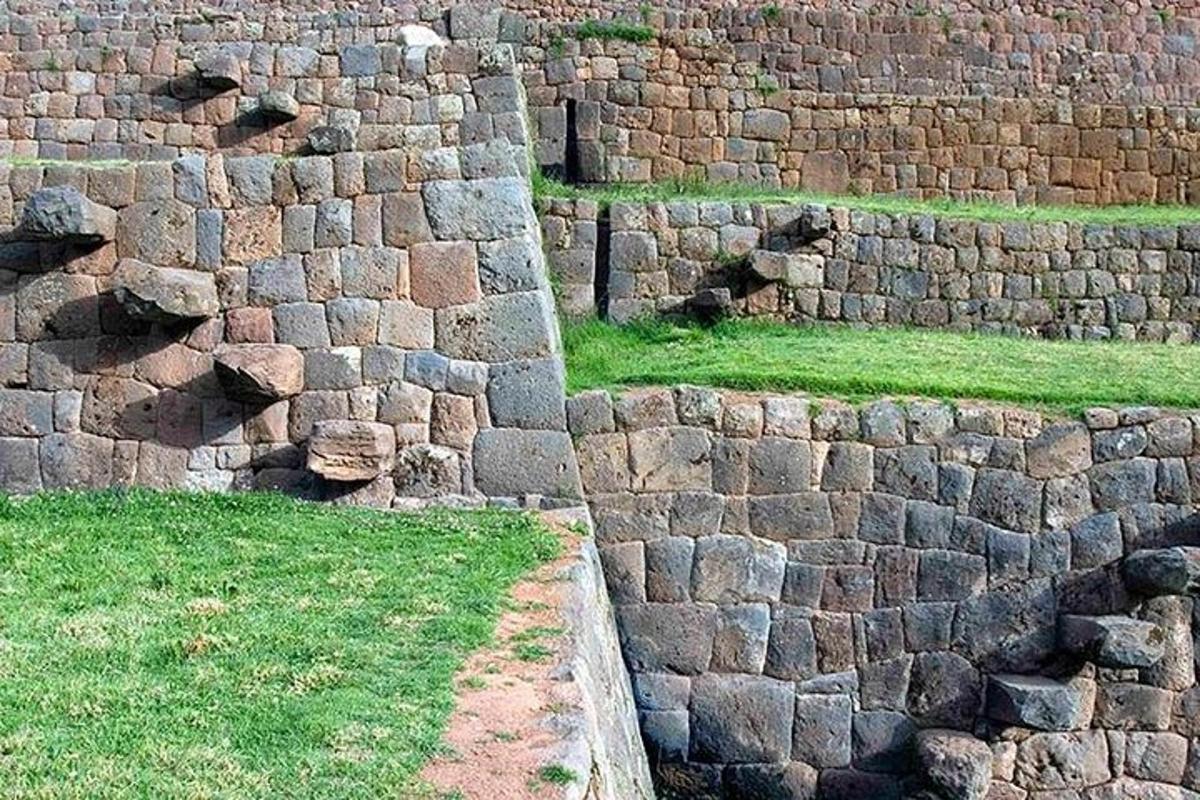 Un viejo muro de piedra con césped verde al lado.