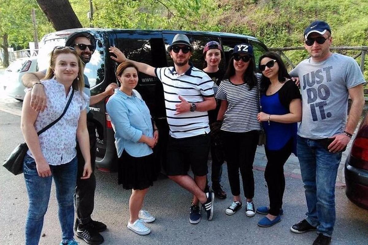 eine Gruppe von Menschen steht vor einem Auto