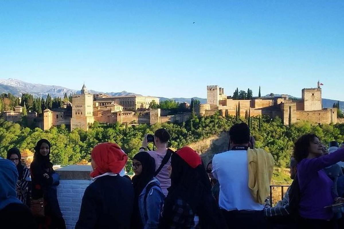 un gruppo di persone sedute su un muro che guardano una città