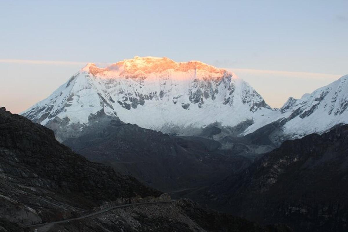 a snow covered mountain with the sun shining on it