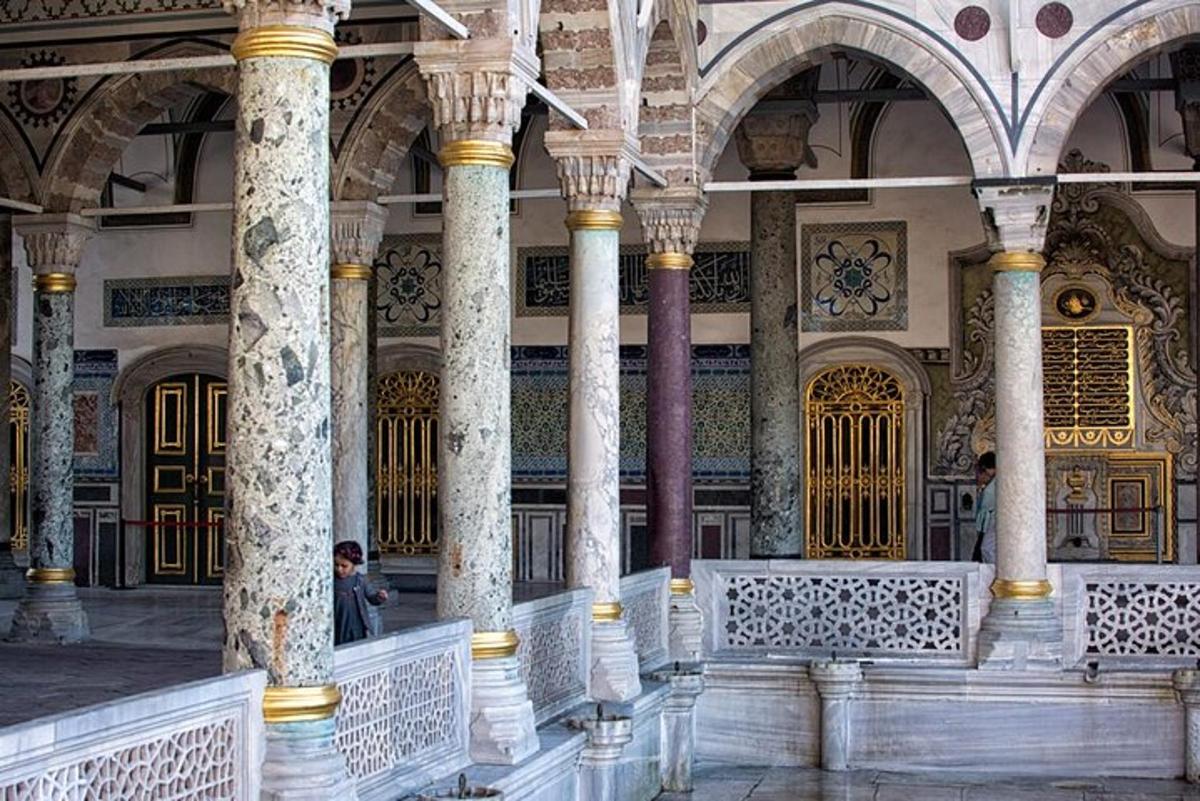 ένα κτίριο με κολώνες και ένα άτομο που κάθεται σε ένα παγκάκι