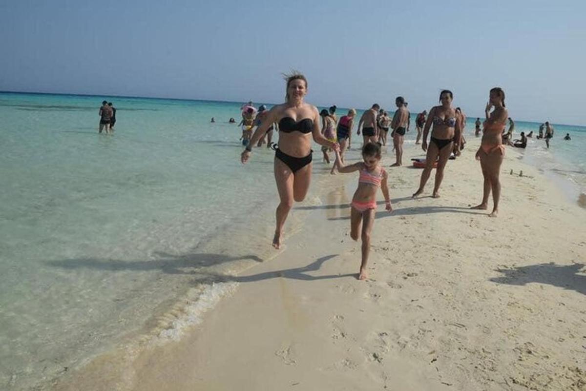um grupo de pessoas correndo na praia