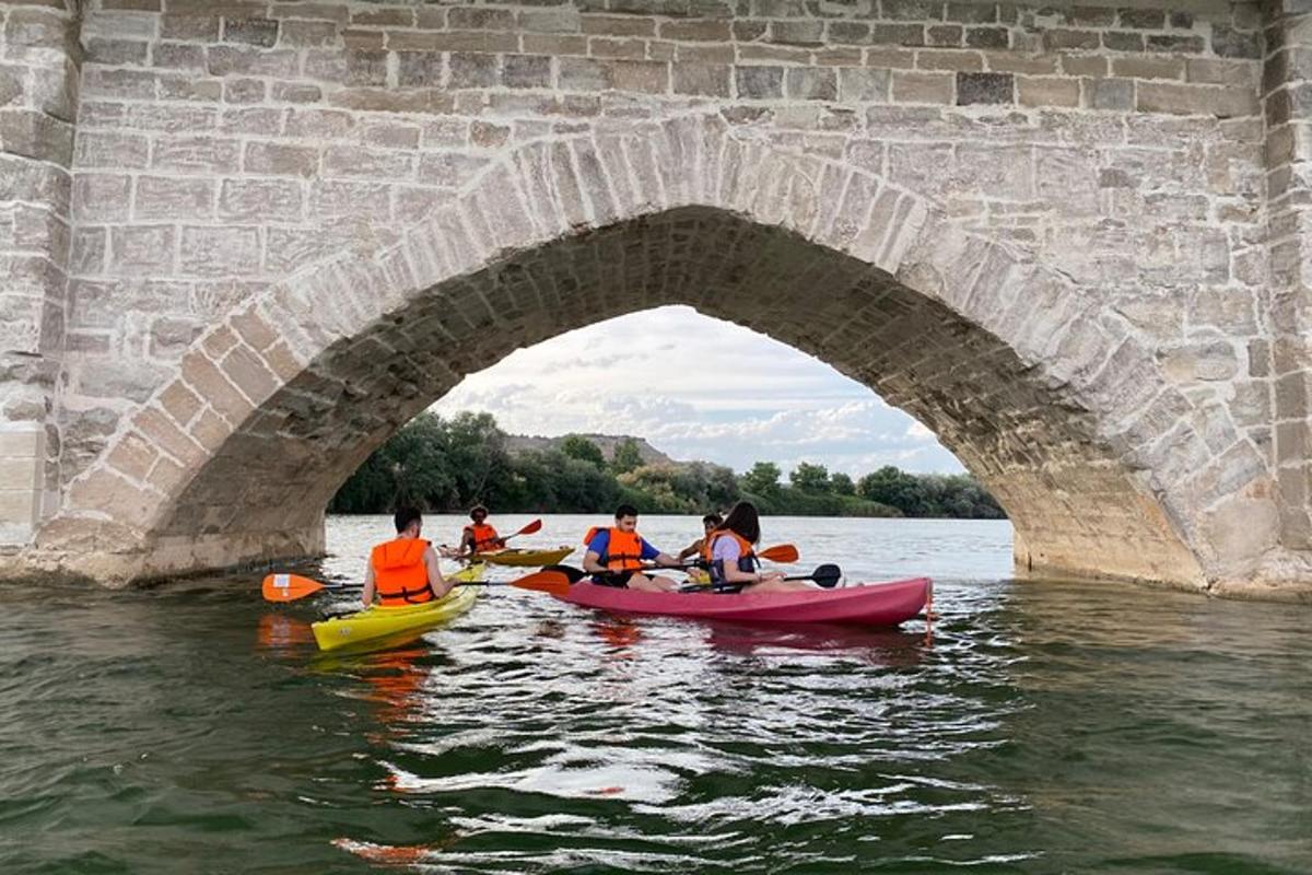 un gruppo di persone in kayak sotto un ponte