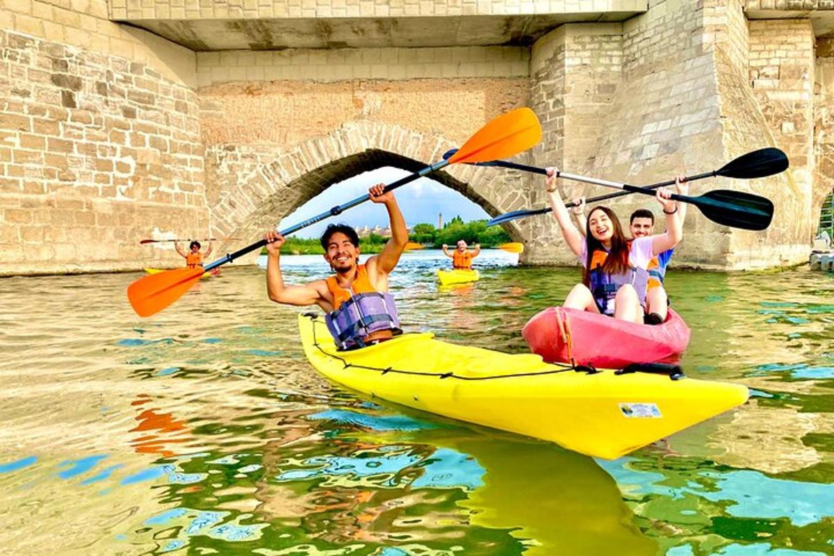 due persone in kayak sull'acqua sotto un ponte
