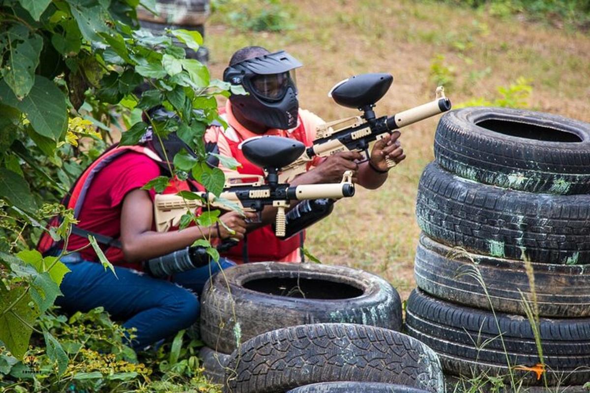dua orang dengan pistol di sebelah timbunan tayar