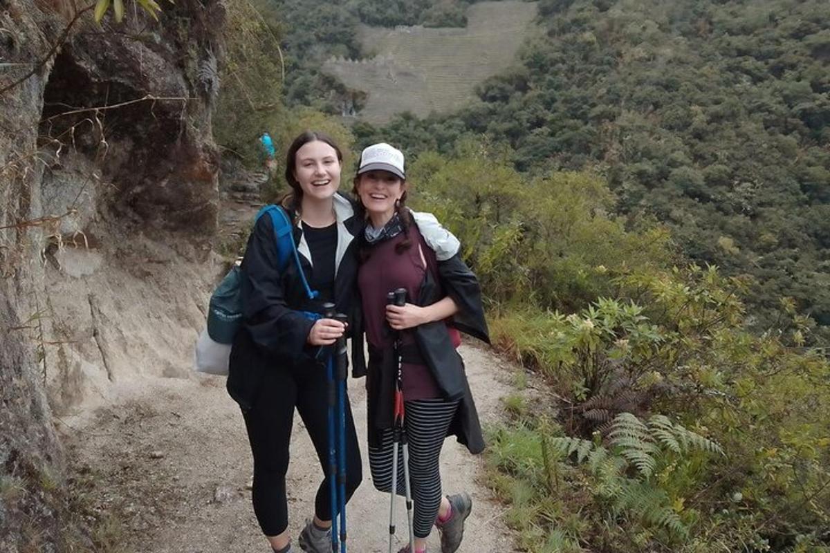 two women are standing on a mountain trail