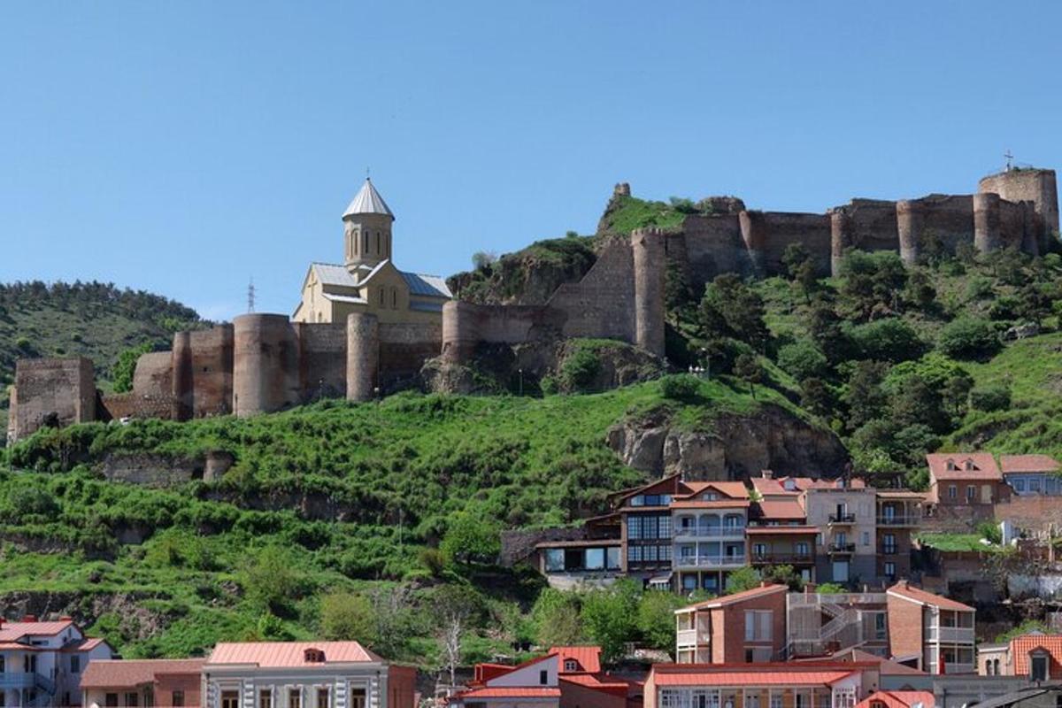hrad na vrcholu kopce s domy