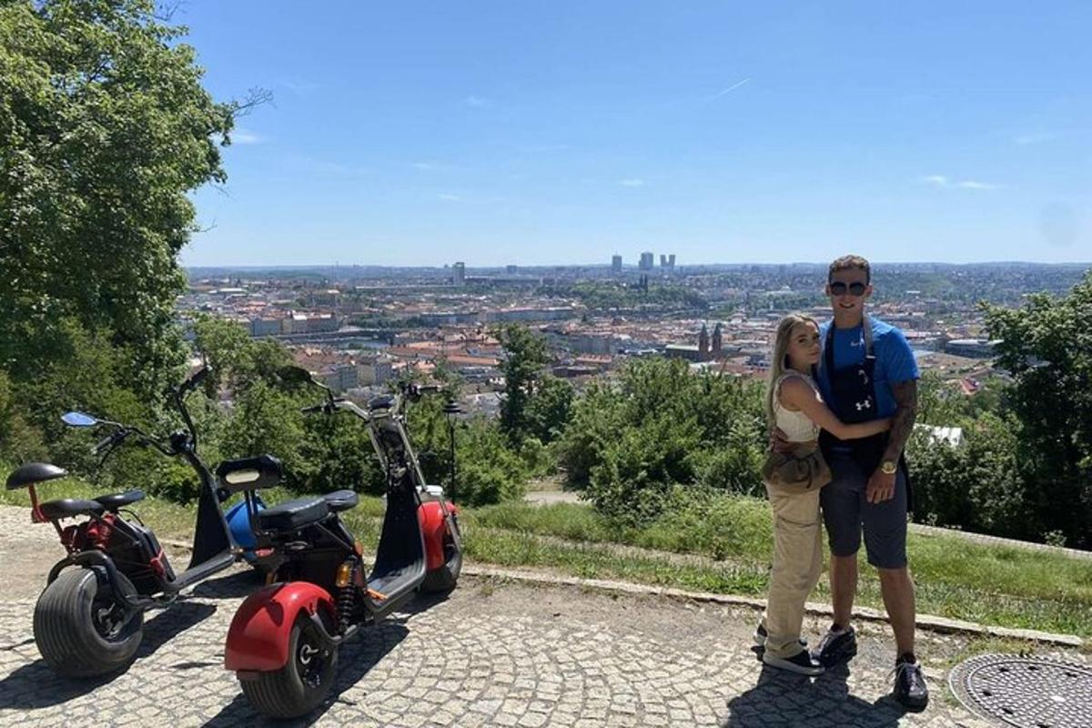 muž a žena stojící vedle dvou skútrů