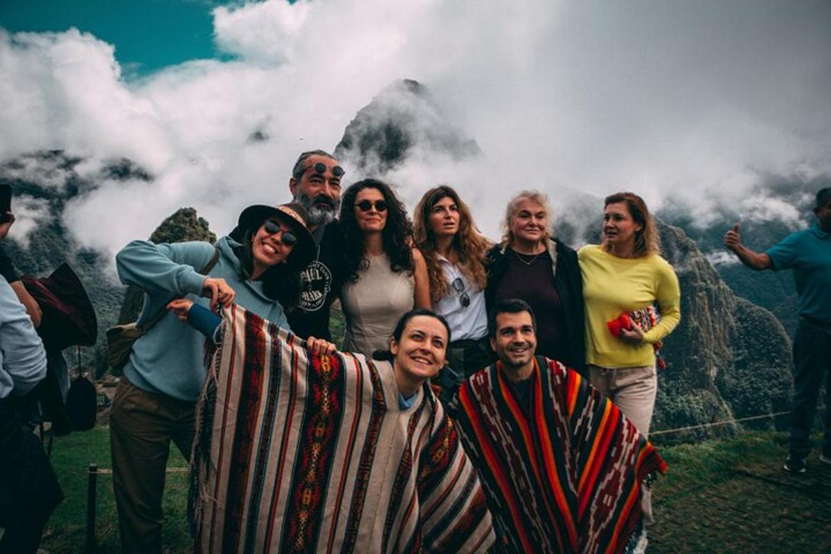sekelompok orang berpose untuk foto di depan gunung