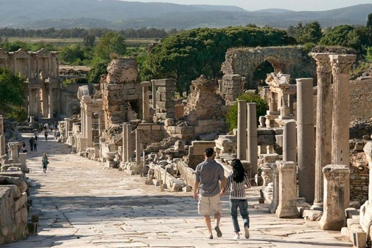 Un hombre y una mujer caminando por las ruinas
