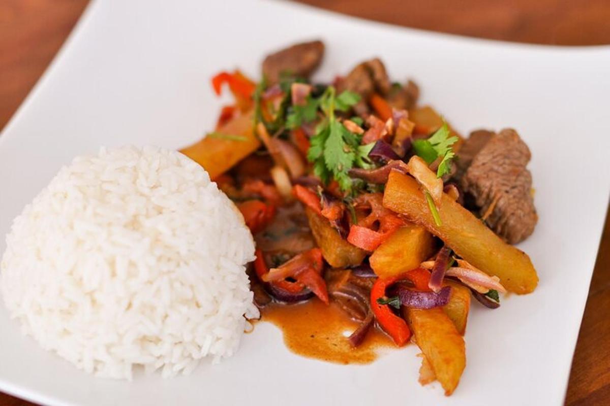 um prato branco de comida com arroz e carne
