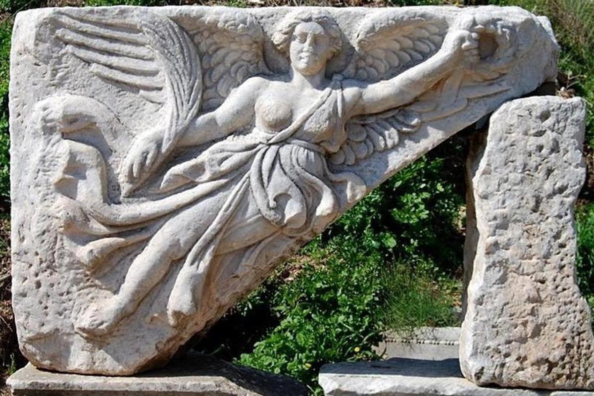 una statua di un angelo su un muro di pietra