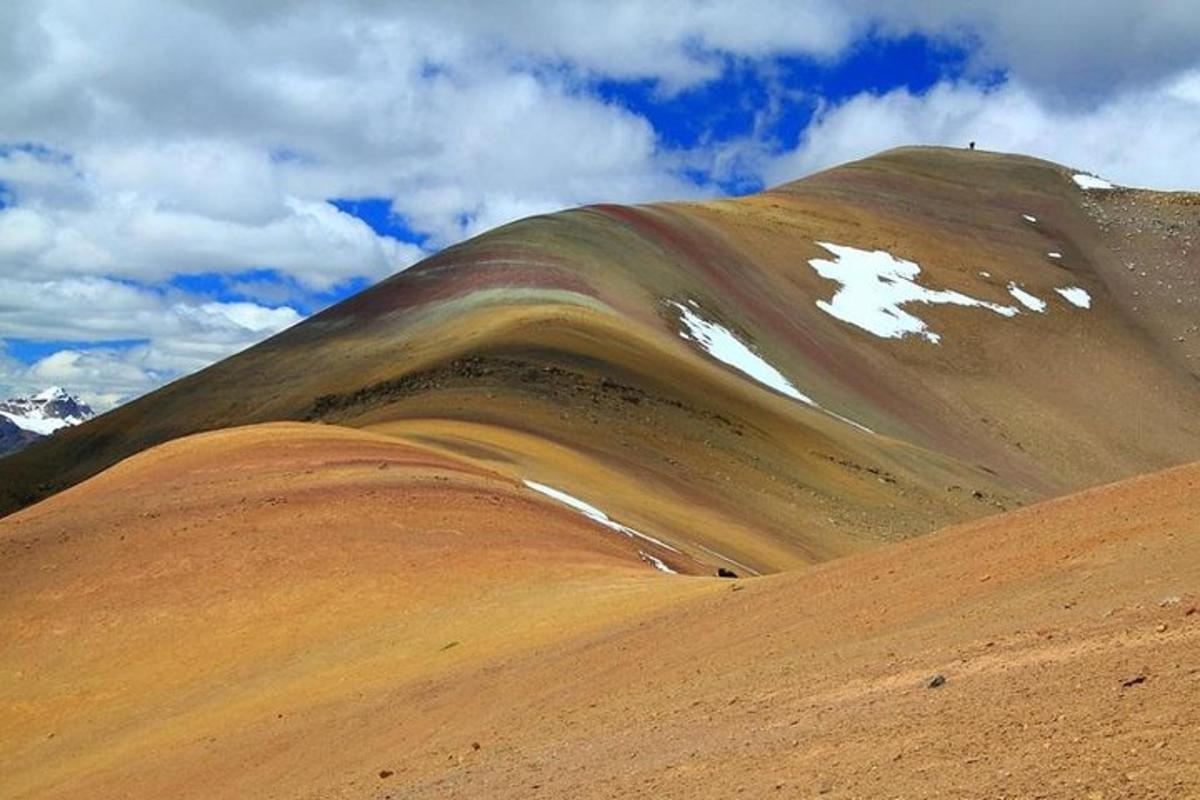 una collina marrone con una montagna sullo sfondo