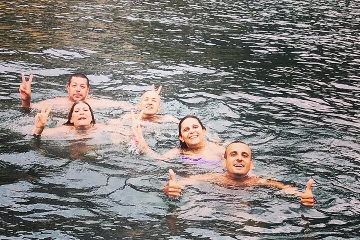 um grupo de pessoas na água fazendo sinal de positivo