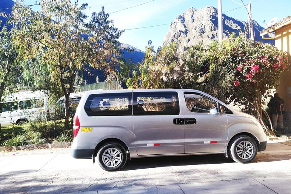 sebuah mobil van berwarna perak terparkir di pinggir jalan