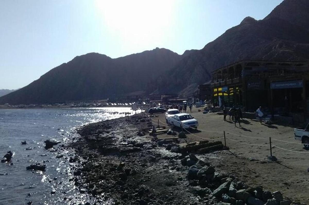 suyun yanındaki bir plajda park etmiş bir grup araba