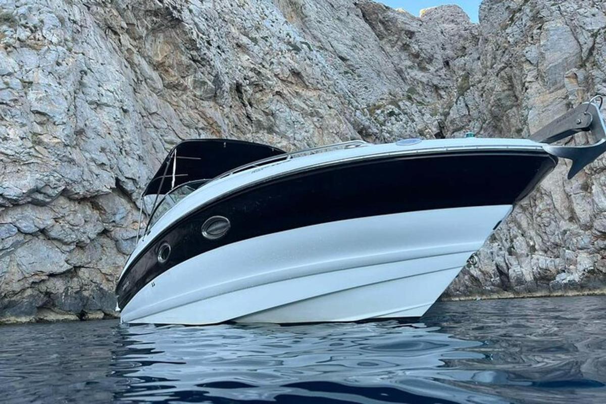 un vaixell assegut a l'aigua al costat d'un penya-segat