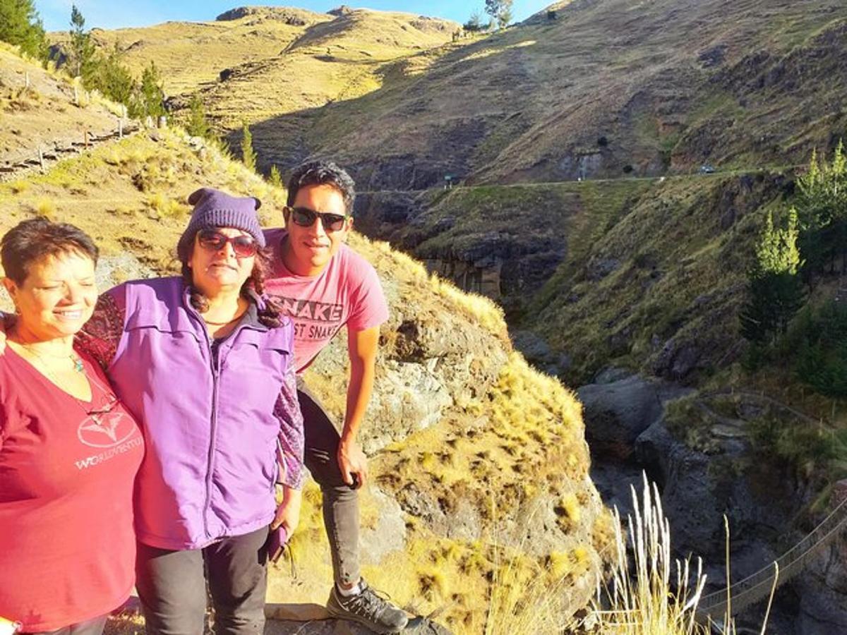 sekumpulan tiga orang berdiri di atas gunung