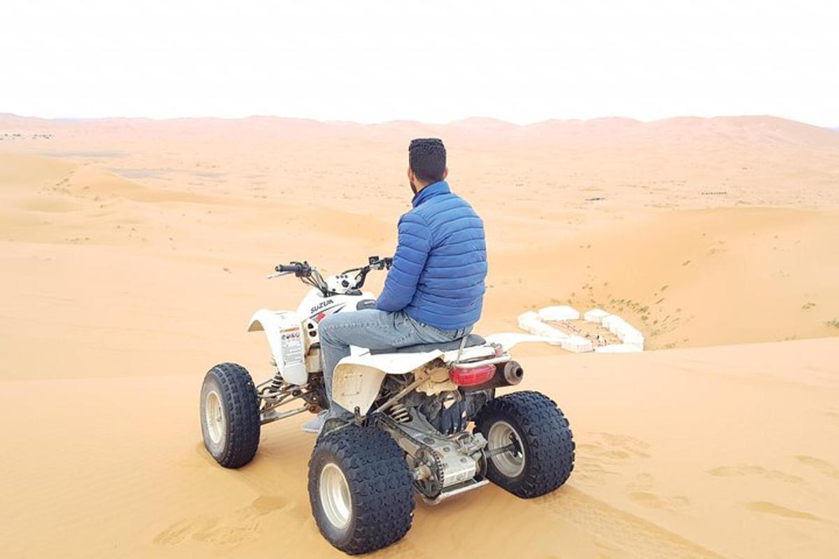 Un hombre sentado en un quad en el desierto