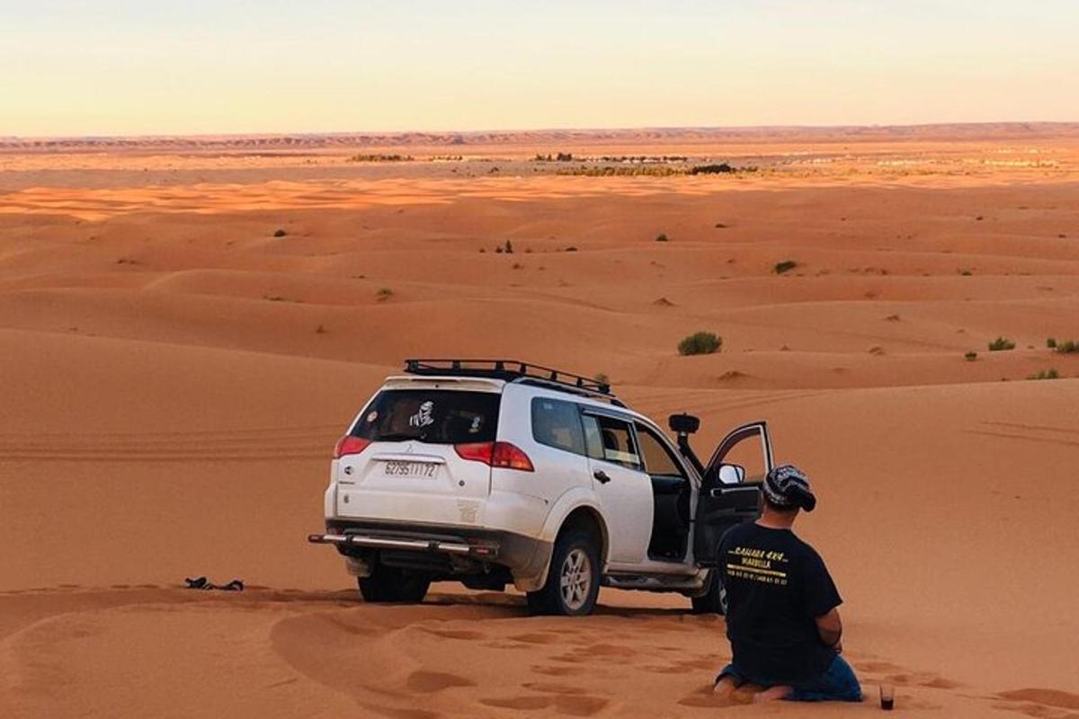 un home dret al costat d'un camió blanc al desert