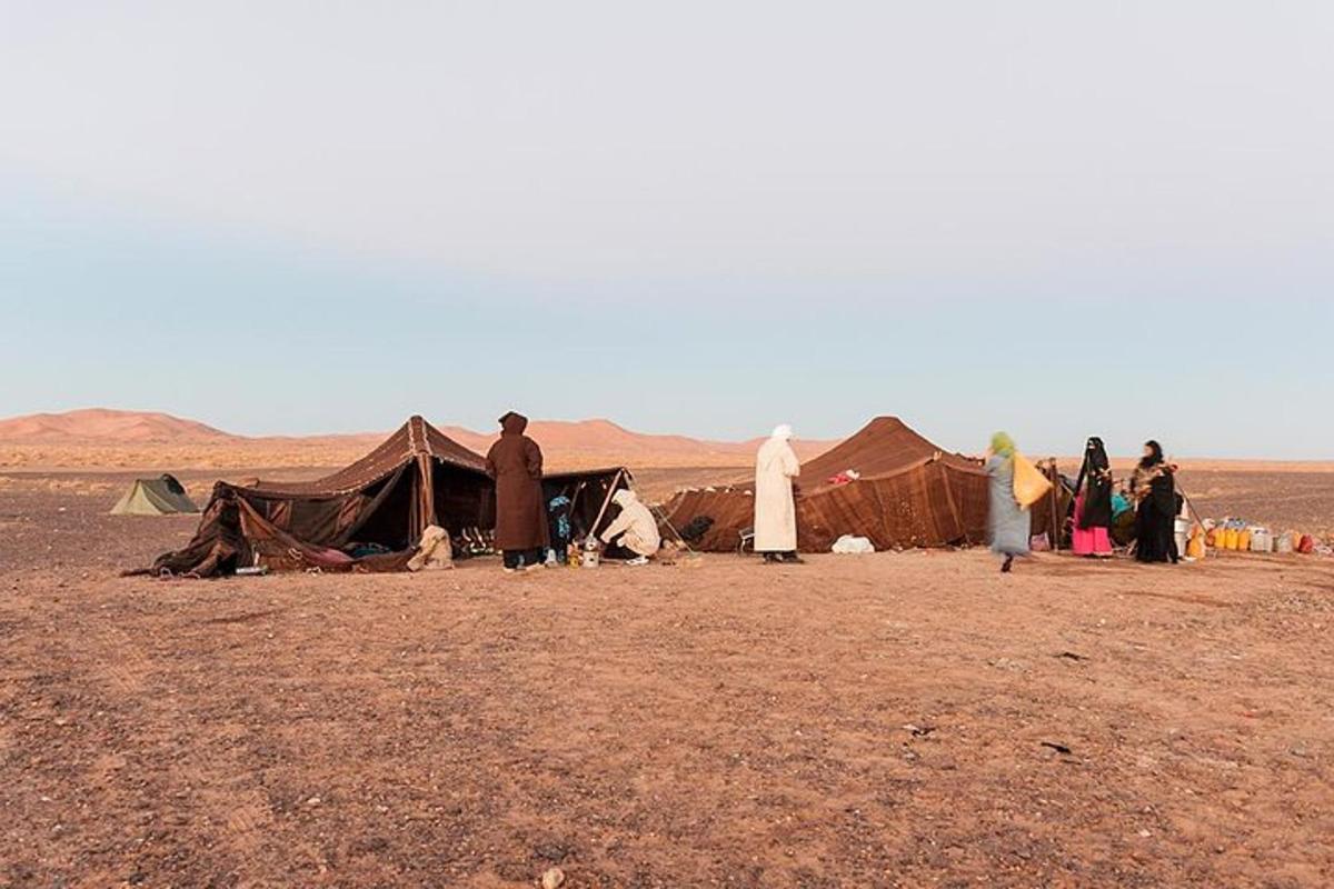 un grup de persones al voltant d'una tenda al desert