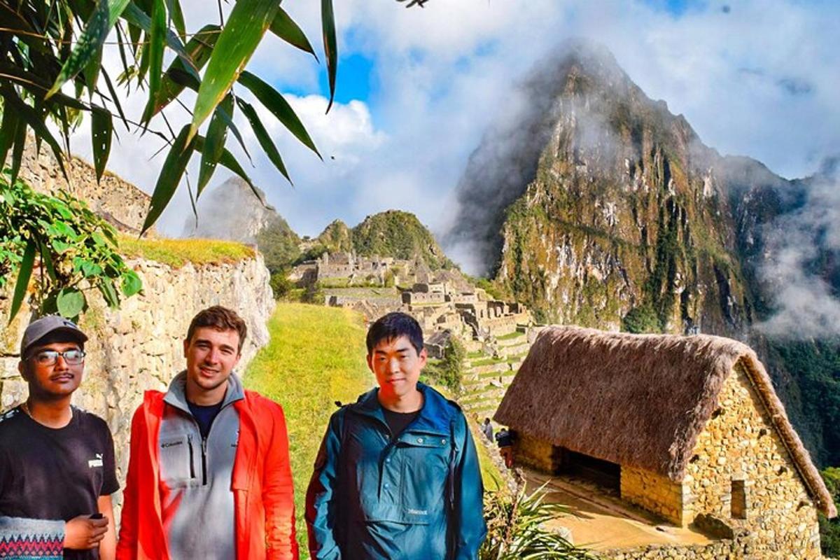 a group of three men standing in front of a mountain
