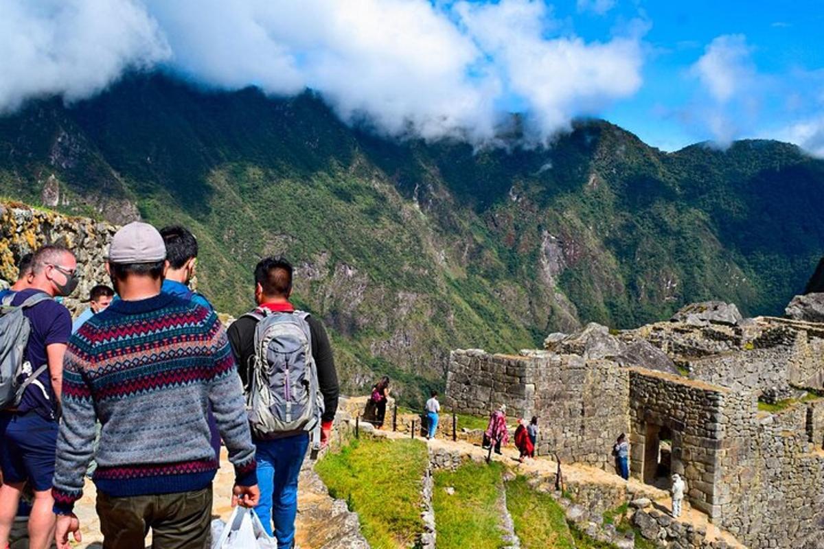a group of people walking on the edge of a mountain