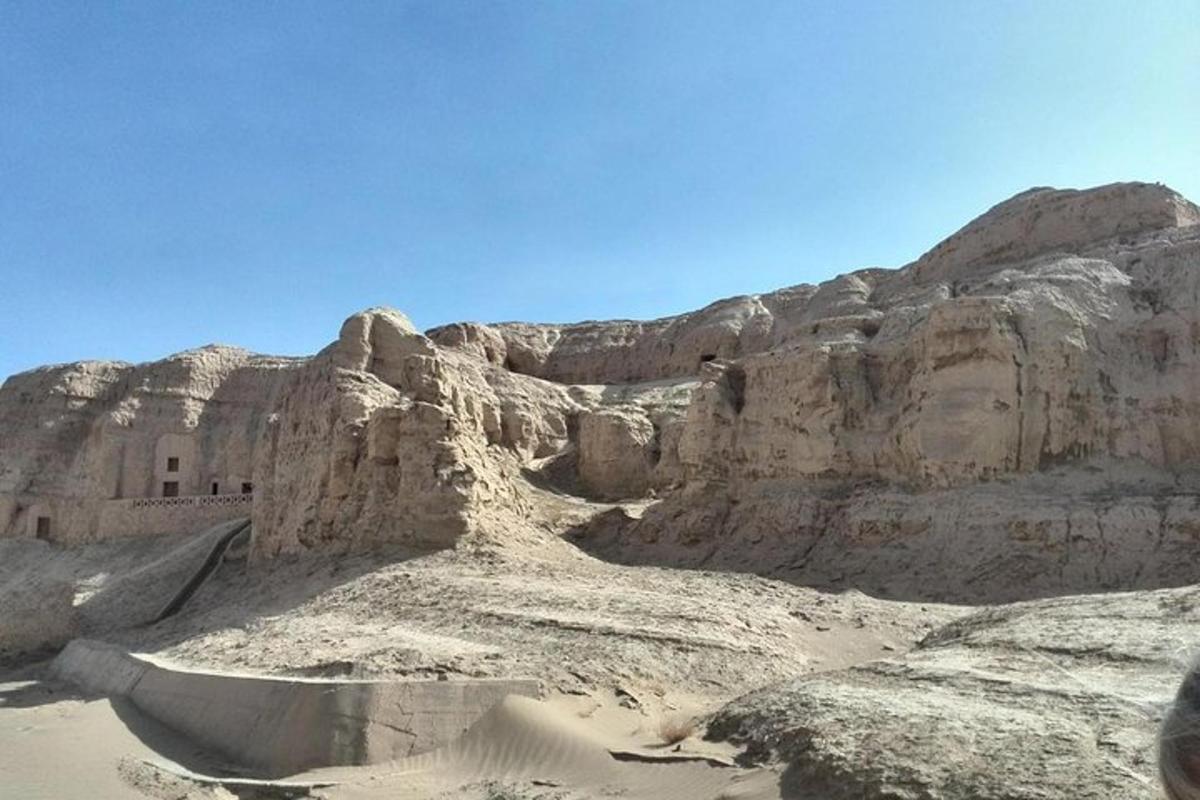 a desert scene with a mountain and a body of water