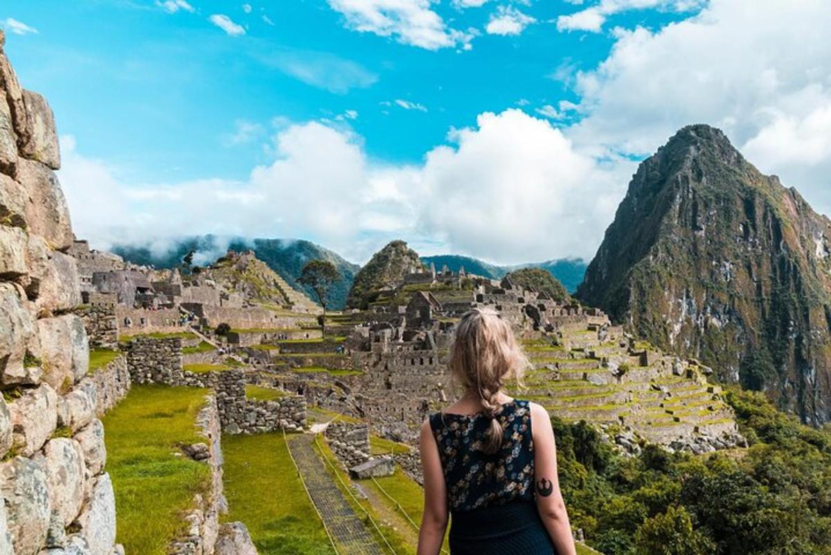 ženska stoji na vrhu ruševin Machu Picchuja