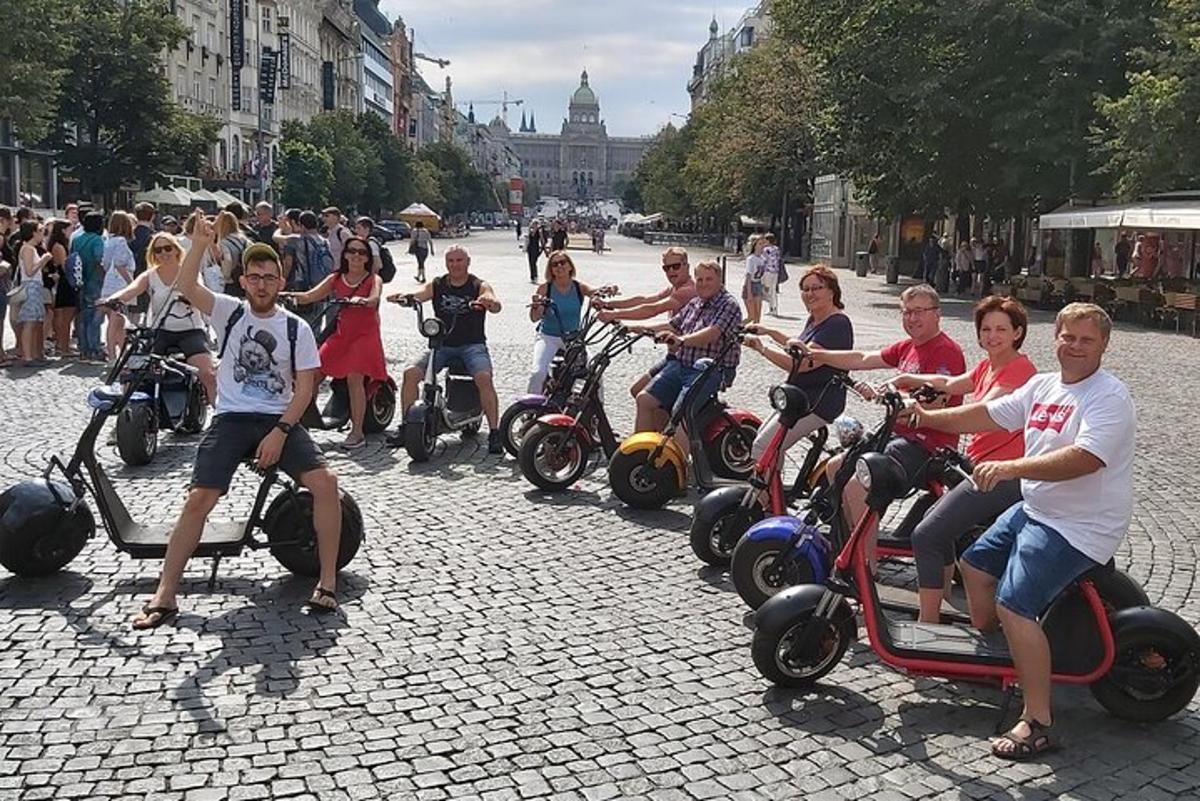 skupina ljudi, ki se vozijo na skuterjih po ulici