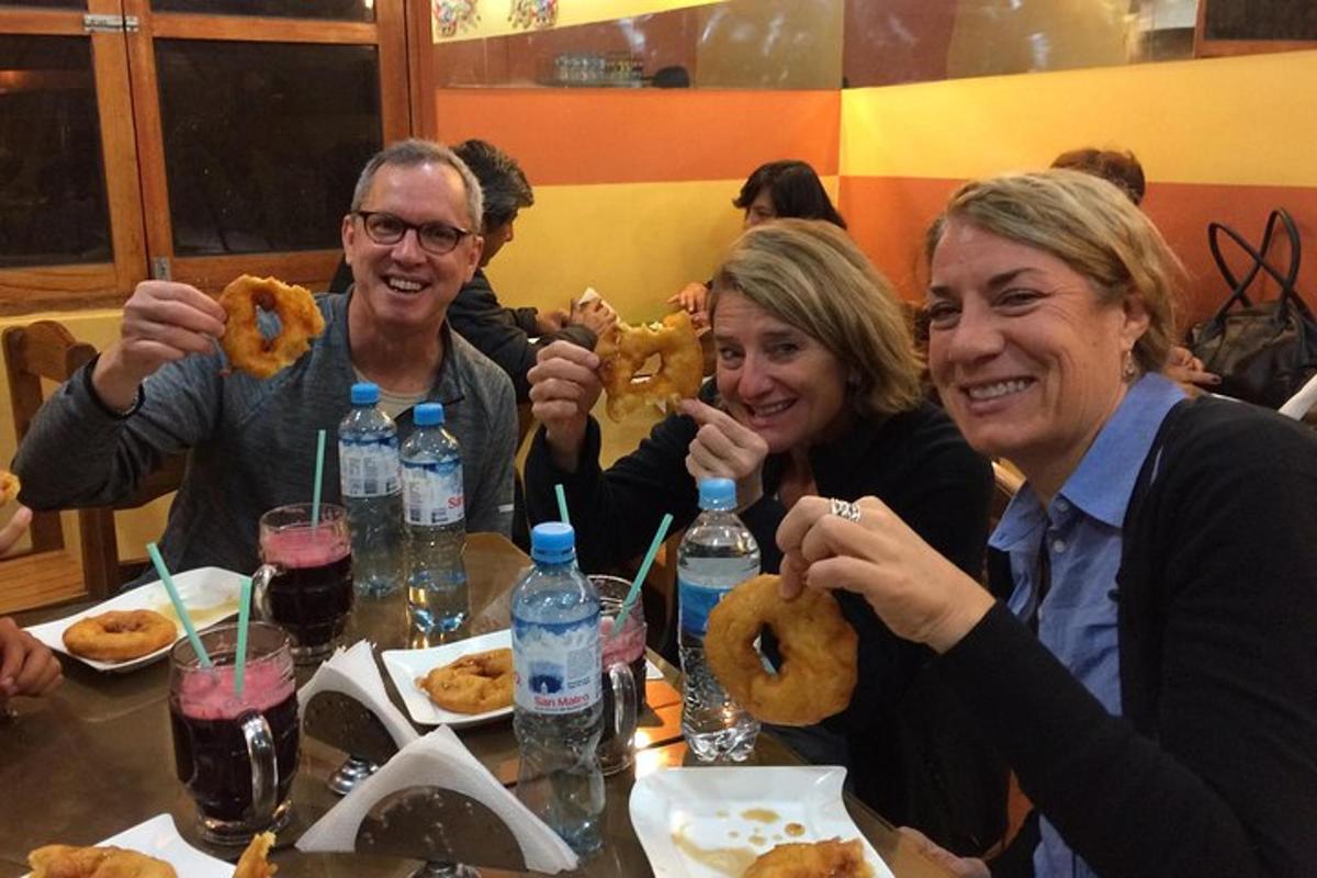 eine Gruppe von Menschen sitzt an einem Tisch und hält Donuts hoch