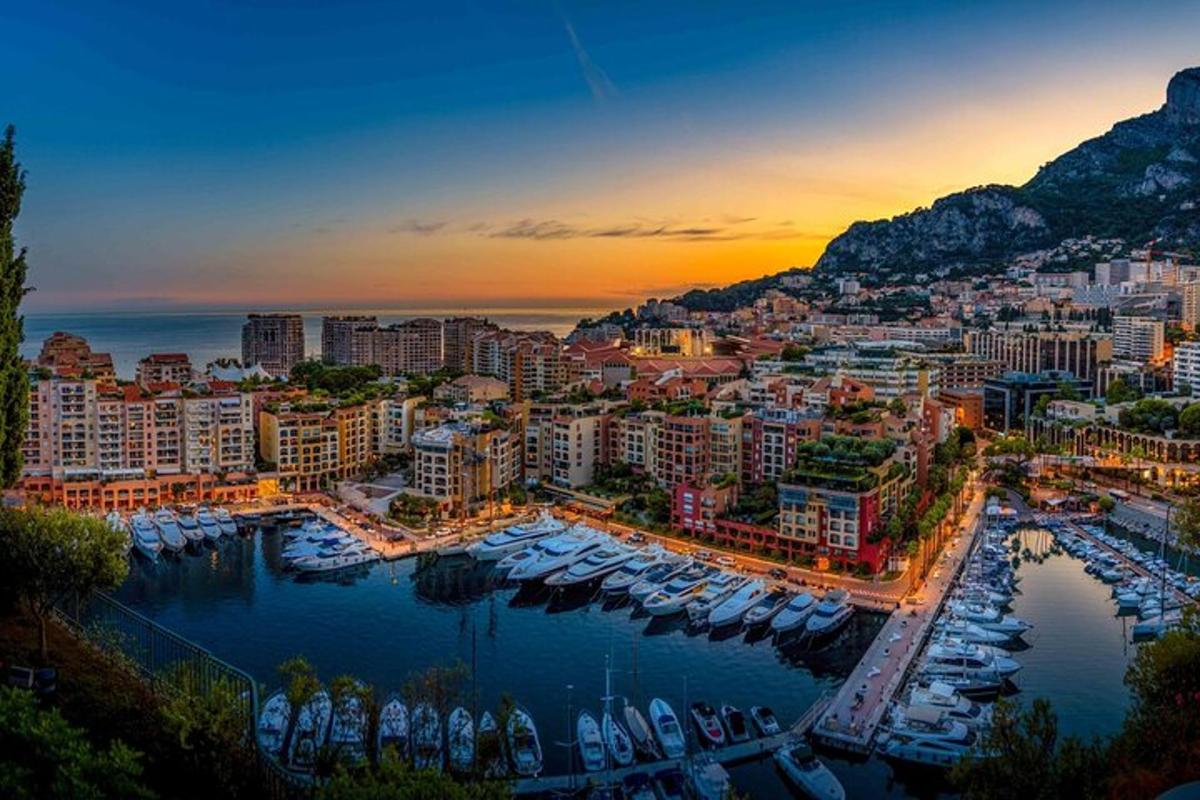 a city with boats in a harbor at sunset