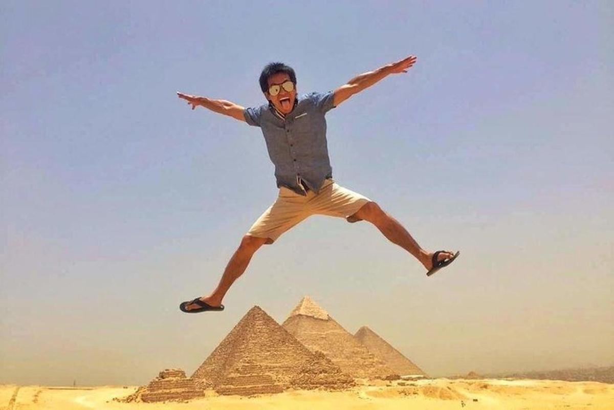 muž skákající do vzduchu před pyramidami