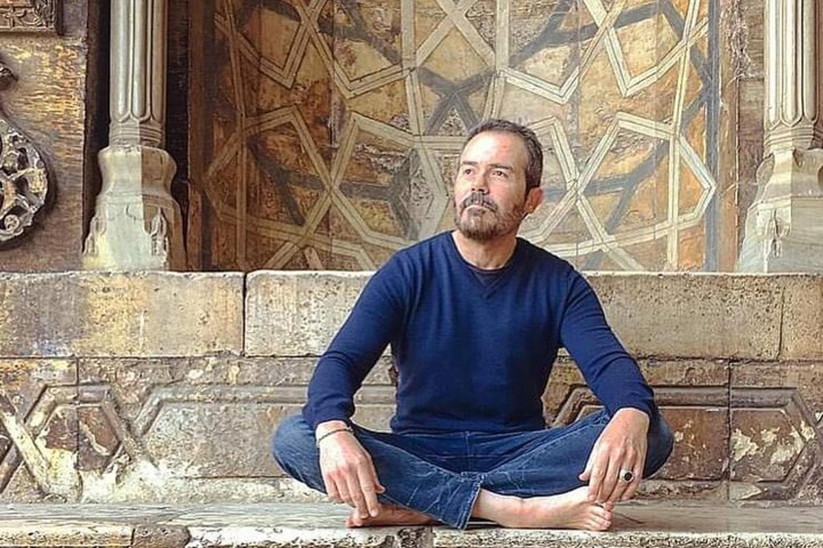 un home assegut a terra en meditació