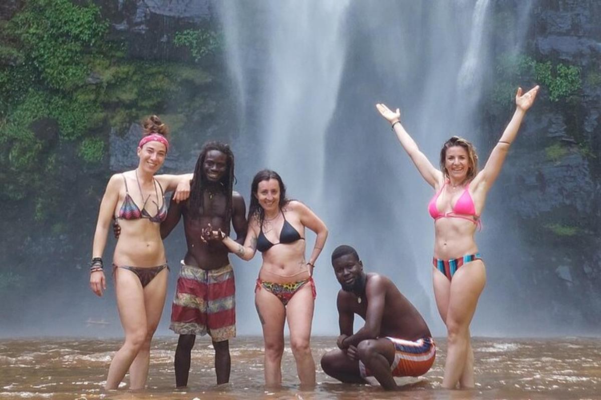 sekumpulan wanita berdiri di dalam air di hadapan air terjun