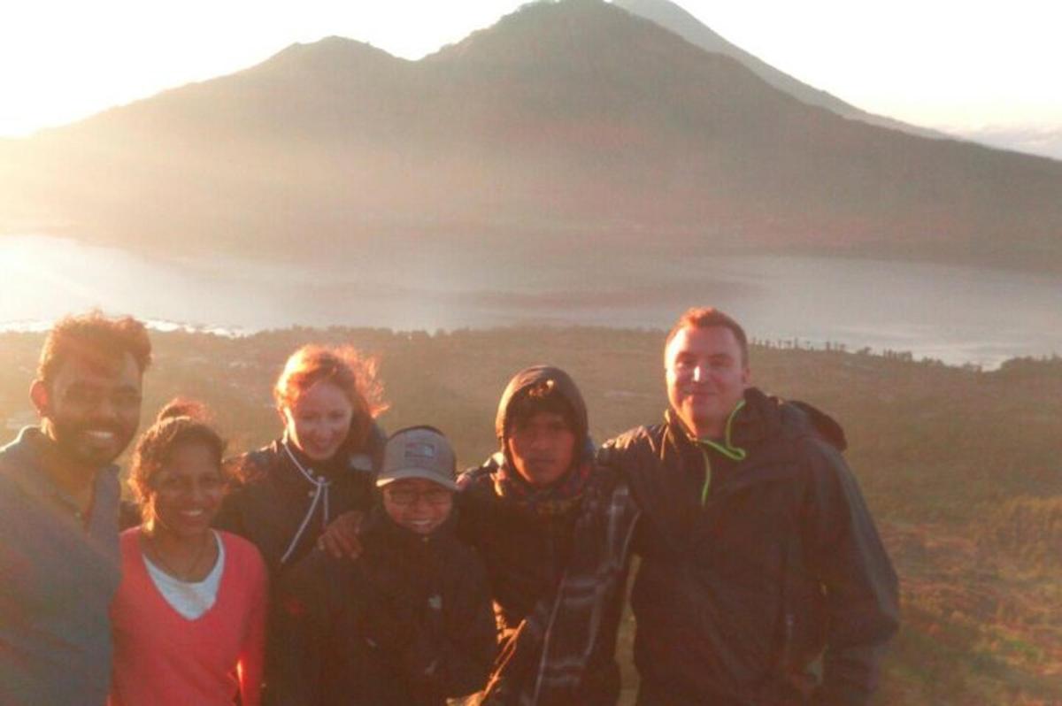 a group of people standing in front of a mountain