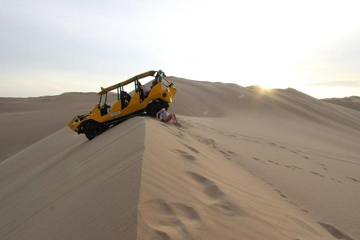 een gele vrachtwagen in het zand in de woestijn
