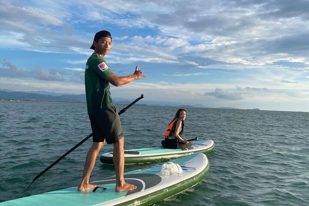 een man die op een paddleboard in het water staat