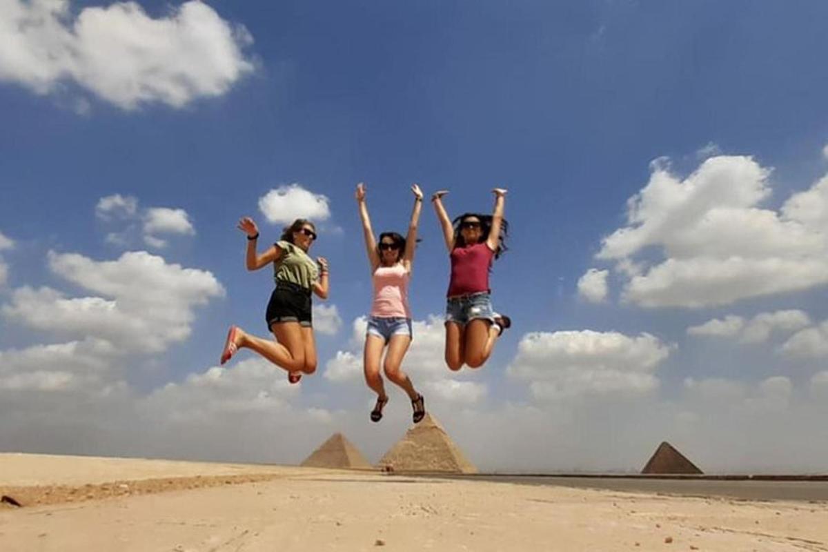 Tres niñas saltando en el aire frente a las pirámides
