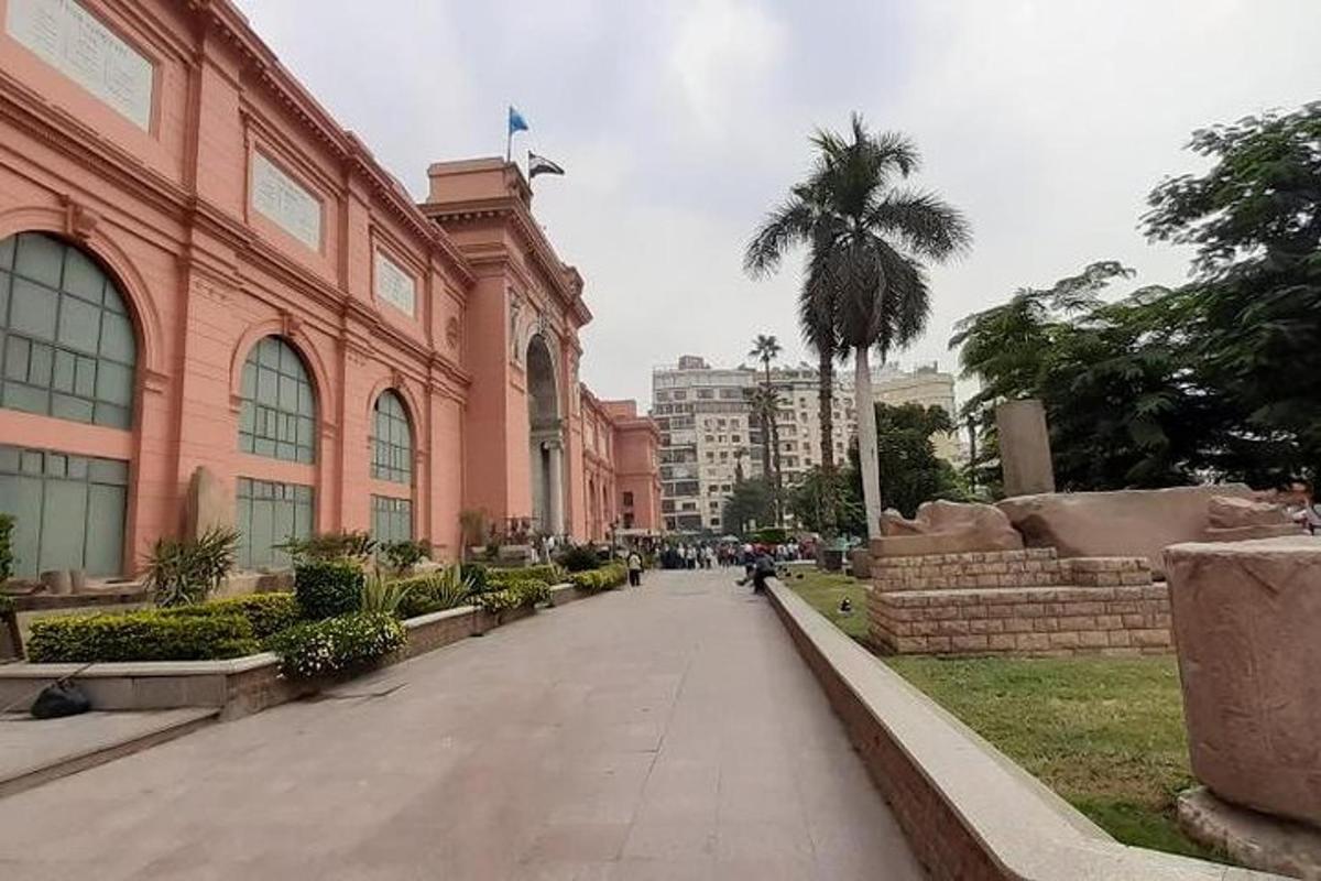 Una calle frente a un edificio con una palmera.