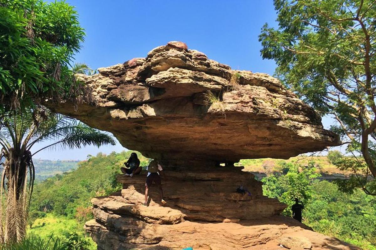 dua orang berdiri di atas batu
