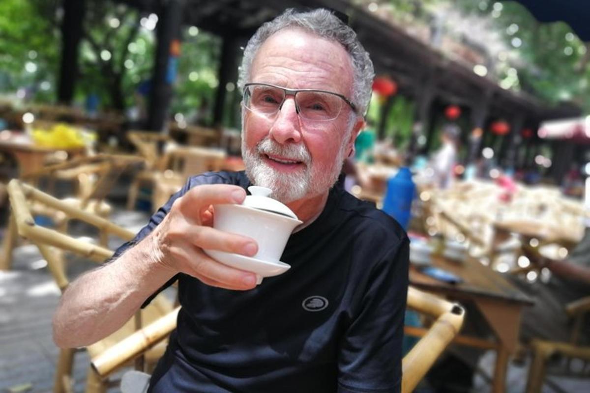 an older man is drinking a cup of coffee