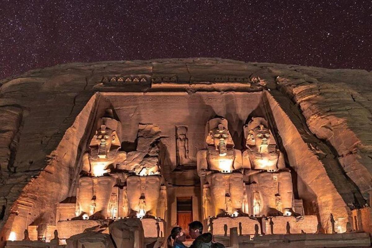 Un grupo de personas de pie frente a un templo de piedra.