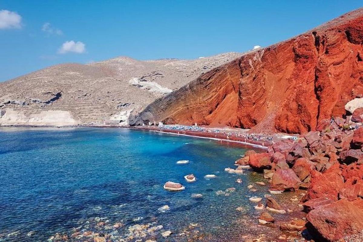 μια θέα σε μια παραλία με έναν κόκκινο βράχο