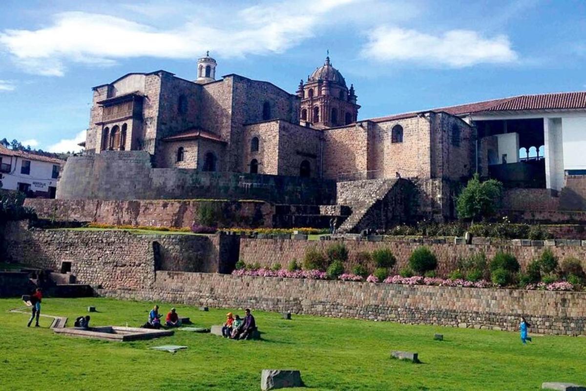 un grup de persones assegudes en un camp davant d'un castell