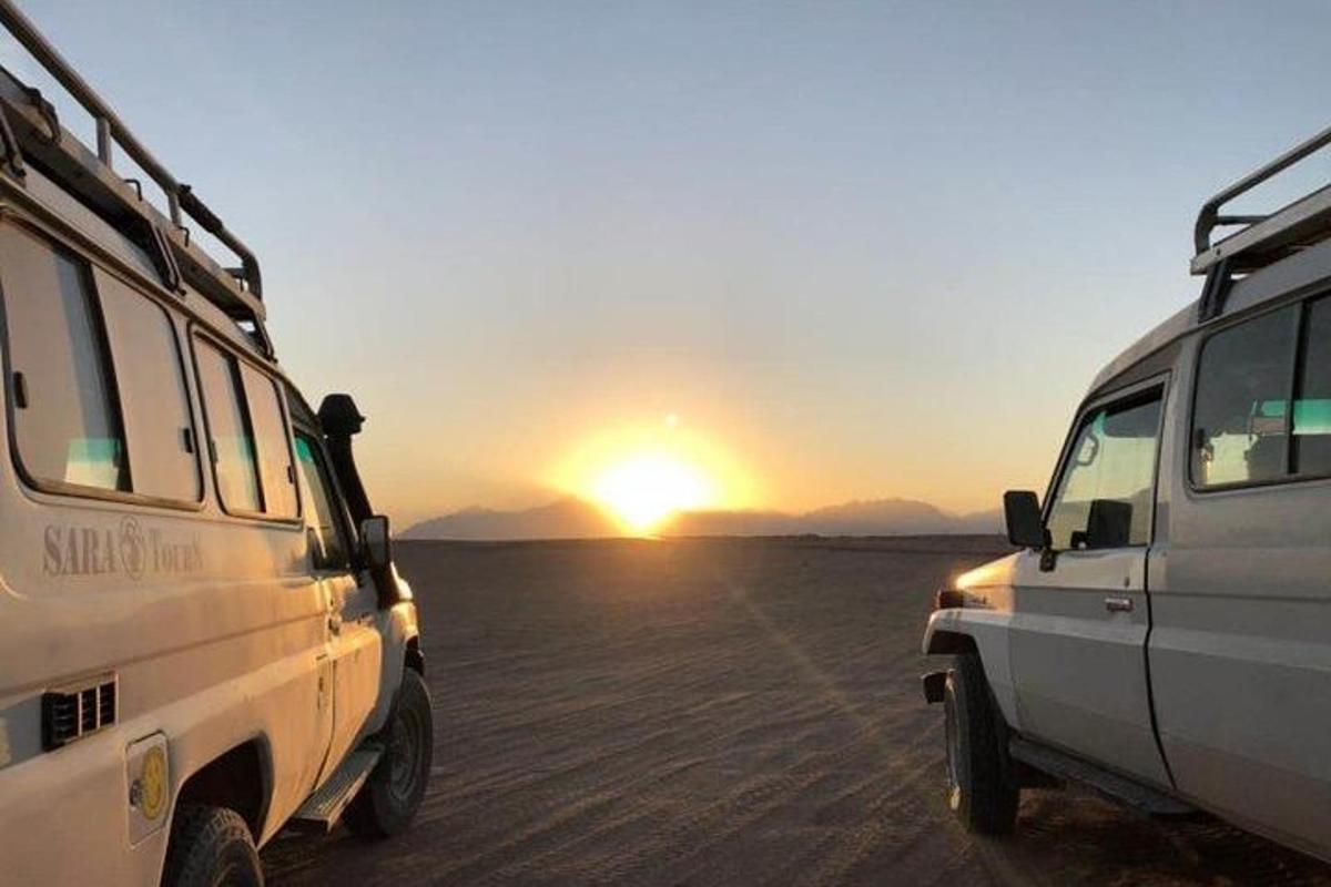 zwei weiße Lieferwagen parkten bei Sonnenuntergang in der Wüste
